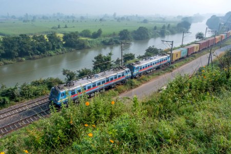 Photo for Pune, India - October 15 2023: Container freight train hauled by WAG7 twin electric locomotives near Pune India. - Royalty Free Image