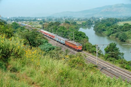 Photo for Pune, India - October 15 2023: WCAM2P electric locomotive hauls a passenger train near Pune India. - Royalty Free Image