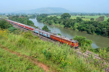 Photo for Pune, India - October 15 2023: WCAM2P electric locomotive hauls a passenger train near Pune India. - Royalty Free Image