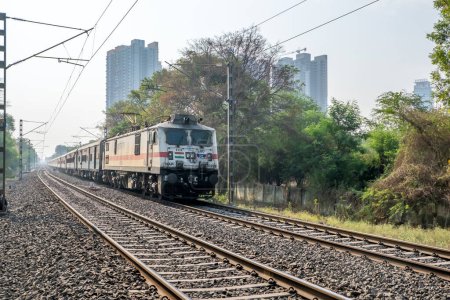 Photo for Pune, India - April 09 2023: Passenger train hauled by a WAP7 electric locomotive near Pune India. - Royalty Free Image