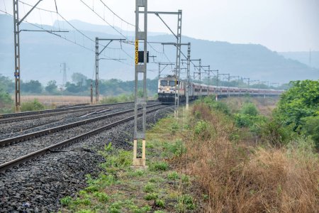 Photo for Pune, India - May 07 2023: Passenger train hauled by a WAP7 electric locomotive near Pune India. - Royalty Free Image