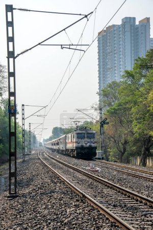 Photo for Pune, India - May 06 2023: Passenger train hauled by a WAP7 electric locomotive near Pune India. - Royalty Free Image