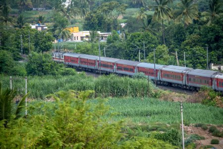Photo for Pune, India - June 11 2023: Passenger train hauled by a WAP7 electric locomotive near Pune India. - Royalty Free Image