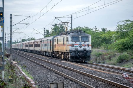 Photo for Pune, India - July 09 2023: Passenger train hauled by a WAP7 electric locomotive near Pune India. - Royalty Free Image