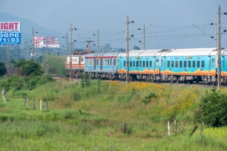 Photo for Pune, India - October 14 2023: Passenger train hauled by a WAP7 electric locomotive near Pune India. - Royalty Free Image
