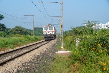 Photo for Pune, India - October 15 2023: Passenger train hauled by a WAP7 electric locomotive near Pune India. - Royalty Free Image