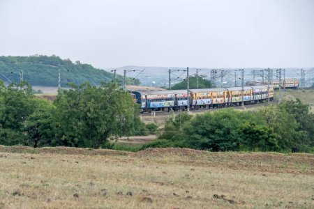 Photo for Pune, India - October 24 2023: WCAM2P electric locomotive hauls a passenger train near Pune India. - Royalty Free Image