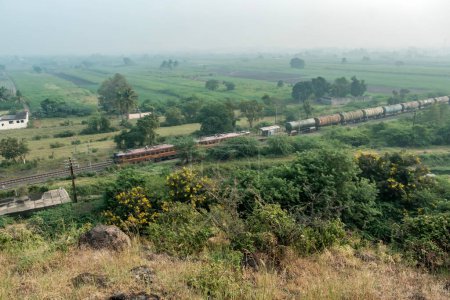 Photo for Pune, India - October 22 2023: Oil tanker train hauled by a WAG7 electric locomotives near Pune India. - Royalty Free Image
