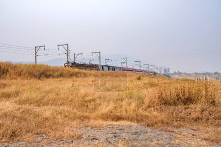 Photo for Pune, India - November 05 2023: WCAM2P electric locomotive hauls a passenger train near Pune India. - Royalty Free Image