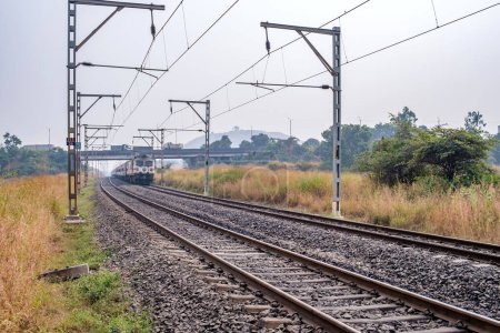 Photo for Pune, India - November 05 2023: Passenger train hauled by a WAP7 electric locomotive near Pune India. - Royalty Free Image