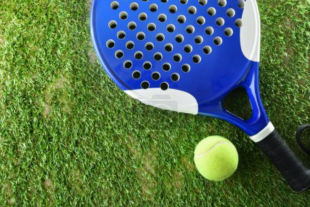Foto de Background of padel racket and ball on artificial grass floor in outdoor court. Top view. - Imagen libre de derechos