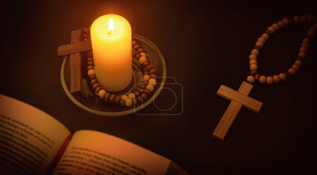 Foto de Ambiente espiritual cristiano para rezar con vela iluminando el símbolo de la cruz y la Biblia en la mesa negra por la noche. Vista superior elevada. - Imagen libre de derechos