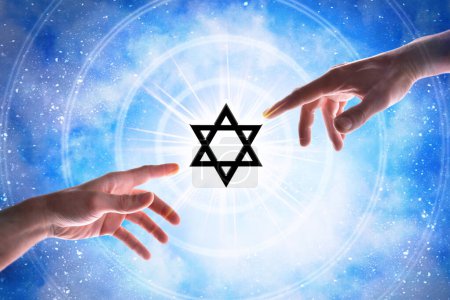 Manos señalando el símbolo judío con círculos concéntricos con un destello de luz sobre un fondo mágico estrellado azulado del universo.