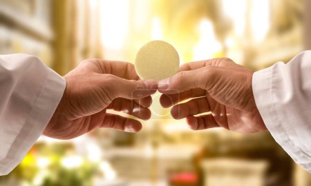 Téléchargez les photos : Mains d'un prêtre consacrant une hostie comme le corps du Christ pour la distribuer aux communicants dans l'église - en image libre de droit