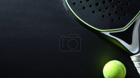 Foto de Fondo detallado de raqueta de padel blanco y negro y bola sobre fondo negro. Vista superior. - Imagen libre de derechos
