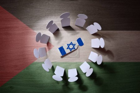 Photo for Concept of rounding up Israeli by Palestinians forces with cutouts of Palestinians men around cutout of Israeli man in the center. Top view. - Royalty Free Image