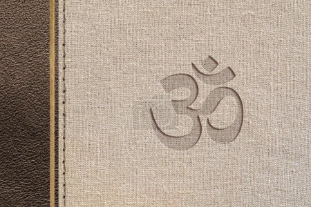 Diseño religioso hindú marrón con textura de cuero y tela con símbolo hindú grabado. Vista superior.