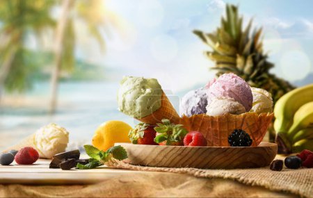 Assorted fruit ice cream on wooden table on sand with tropical beach background