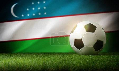 Composition de l'équipe nationale d'Ouzbékistan avec balle classique sur herbe et drapeau en arrière-plan. Vue de face.