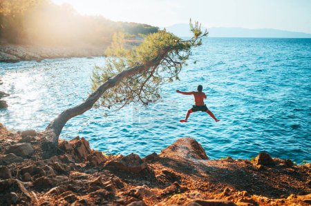Photo for Man Jumping to the water of blue Mediterranean Sea. Active Summer vacation in Croatia. Photo full of Energy, Edit space - Royalty Free Image