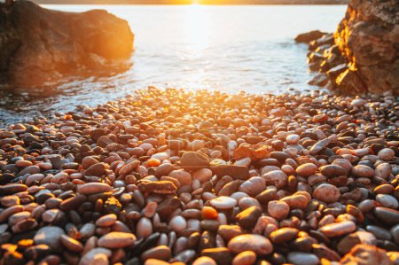 Photo for Pebbles on the beach. Summer Holiday in Croatia. beautiful Wallpaper. Gold orange colors. Warm sunset light. White edit space - Royalty Free Image