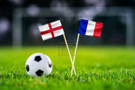 Photo for England - France. Quarter-finals football match. Round of 8. Handmade national flags and soccer ball on green grass. Football stadium in background. Black edit space. - Royalty Free Image