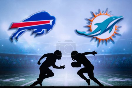 Téléchargez les photos : BUFFALO, USA, JANUARY 10, 2023: Miami Dolphins vs. Buffalo Bills. NFL Wild Card Round 2023, Silhouette of two NFL American Football Players against each other. Big screen in background - en image libre de droit
