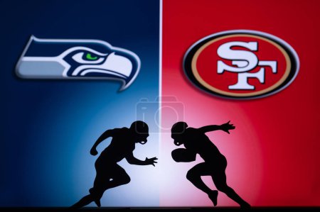 Foto de SAN FRANCISCO, USA, JANUARY 10, 2023: Seattle Seahawks vs. San Francisco 49ers. NFL Wild Card Round 2023, Silhouette of two NFL American Football Players against each other. Big screen in background - Imagen libre de derechos