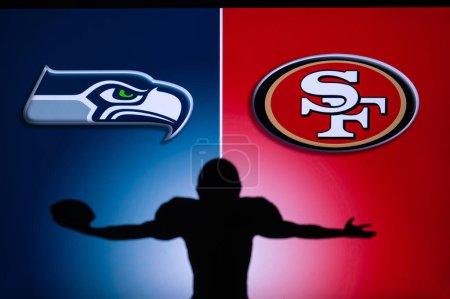 Foto de SAN FRANCISCO, USA, JANUARY 10, 2023: Seattle Seahawks vs. San Francisco 49ers. NFL Wild Card Round 2023, Silhouette of NFL player of american football. holding ball in hand. Big screen in background - Imagen libre de derechos