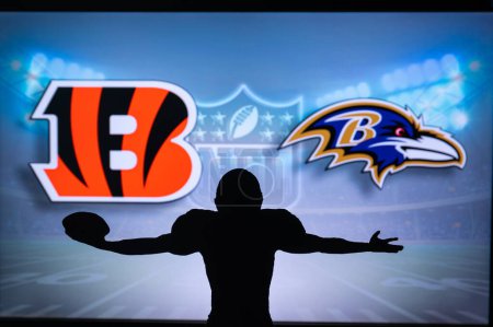 Photo for CINCINNATI, USA, JANUARY 10, 2023: Baltimore Ravens vs. Cincinnati Bengals. NFL Wild Card Round 2023, Silhouette of NFL player of american football. holding ball in hand. Big screen in background - Royalty Free Image