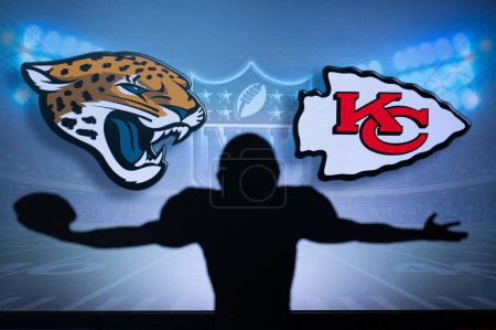 Téléchargez les photos : KANSAS, USA, JANUARY 18, 2023: Jacksonville Jaguars vs. Kansas City Chiefs. NFL Divisional Round 2023, Silhouette of NFL player of american football. holding ball in hand. Big screen in background - en image libre de droit