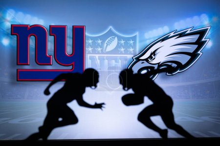Téléchargez les photos : PHILADELPHIA, USA, JANUARY 18, 2023: New York Giants vs. Philadelphia Eagles. NFL Divisional Round 2023, Silhouette of two NFL American Football Players against each other. Big screen in background - en image libre de droit