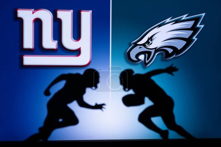 Foto de PHILADELPHIA, USA, JANUARY 18, 2023: New York Giants vs. Philadelphia Eagles. NFL Divisional Round 2023, Silhouette of two NFL American Football Players against each other. Big screen in background - Imagen libre de derechos