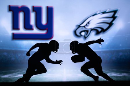 Photo for PHILADELPHIA, USA, JANUARY 18, 2023: New York Giants vs. Philadelphia Eagles. NFL Divisional Round 2023, Silhouette of two NFL American Football Players against each other. Big screen in background - Royalty Free Image