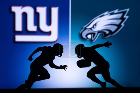 Foto de PHILADELPHIA, USA, JANUARY 18, 2023: New York Giants vs. Philadelphia Eagles. NFL Divisional Round 2023, Silhouette of two NFL American Football Players against each other. Big screen in background - Imagen libre de derechos