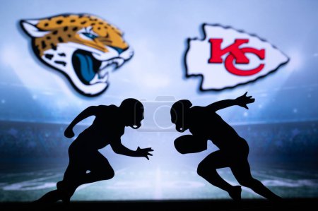 Foto de KANSAS, USA, JANUARY 18, 2023: Jacksonville Jaguars vs. Kansas City Chiefs. NFL Divisional Round 2023, Silhouette of two NFL American Football Players against each other. Big screen in background - Imagen libre de derechos