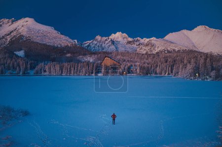 Foto de Man and Winter Nature: The peacefulness of Strbske Pleso in High Tatras on a winter evening, before the sun sets - Imagen libre de derechos