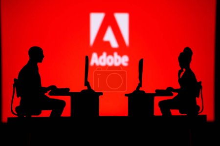 Foto de UK, LONDON. JANUARY 30, 2023: Adobe. Collaboration Leads to Progress: Two Developers Working Together Under the Company's Logo - Imagen libre de derechos