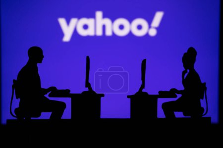 Photo for INDIA, NEW DELHI. JANUARY 30, 2023: Yahoo. Innovating the Future: Silhouette of Two Software Developers and the Company's Logo in the Background - Royalty Free Image