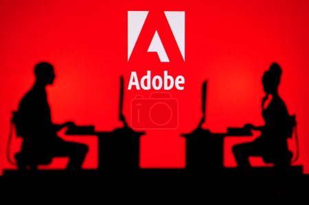 Foto de LOS ANGELES, USA, JANUARY 30, 2023: Adobe. Collaboration Leads to Progress: Two Developers Working Together Under the Company's Logo - Imagen libre de derechos
