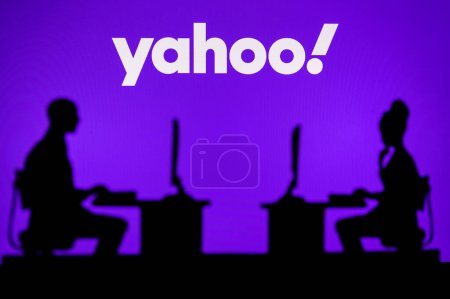 Photo for INDIA, NEW DELHI. JANUARY 30, 2023: Yahoo. Pushing Boundaries with Cutting-Edge Software: Two Developers Silhouetted with Company Logo in Background. - Royalty Free Image