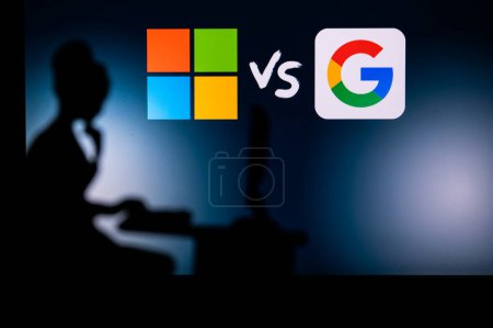 Foto de LOS ANGELES, USA, JANUARY 30, 2023: Microsoft vs Google. Women in Tech: Solo Software Developer Silhouette with Company Logo in Background - Imagen libre de derechos