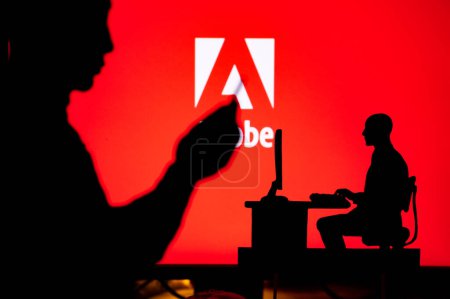 Foto de LOS ANGELES, USA, JANUARY 30, 2023: Adobe. The Intersection of Personal and Professional: Silhouette of Man and Web Developer - Imagen libre de derechos