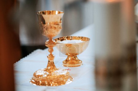 Téléchargez les photos : Capturer le symbolisme sacré : image du calice et du vase eucharistique lors d'une messe momentanée dans un cadre religieux intemporel - en image libre de droit