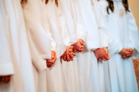 Photo for Innocence in White: Children's Hands in Prayer at the Church - Royalty Free Image