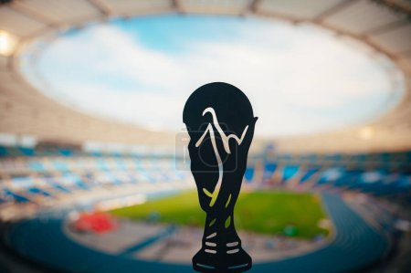 Téléchargez les photos : Silhouette du trophée mondial de football, stade moderne en arrière-plan - en image libre de droit