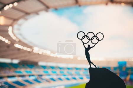 Photo for PARIS, FRANCE, JULY 7, 2023: Embodying Olympic Spirit: Statue of Athlete Holds Olympic Circle High at Modern Olympic Stadium. Capturing the Essence of Paris 2024 Summer Olympics. - Royalty Free Image