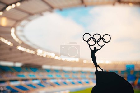 Téléchargez les photos : PARIS, FRANCE, 7 JUILLET 2023 : L'esprit olympique incarne : la statue de l'athlète tient le cercle olympique haut au stade olympique moderne. Saisir l'essence des Jeux olympiques d'été de Paris 2024. - en image libre de droit