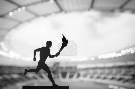 Téléchargez les photos : Passage de la flamme : silhouette de l'athlète masculin en relais de la flamme, face à un stade d'athlétisme moderne. Une image puissante pour l'événement d'été 2024 à Paris - en image libre de droit