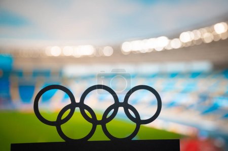 Foto de PARÍS, FRANCIA, 7 DE JULIO DE 2023: Silueta de anillos olímpicos que abarca la magnificencia de un estadio olímpico moderno. París juego olímpico de verano 2024 - Imagen libre de derechos